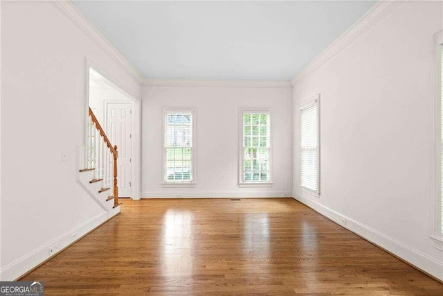 empty room featuring ornamental molding and wood-type flooring