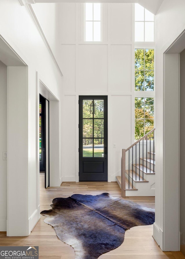 foyer featuring light hardwood / wood-style flooring and a high ceiling