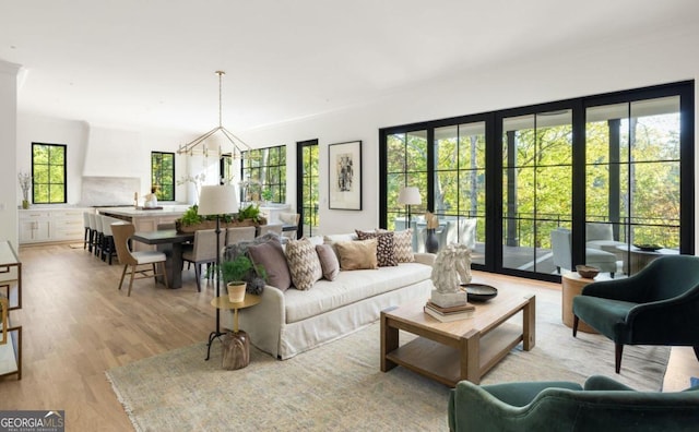 living room with a notable chandelier and light hardwood / wood-style floors