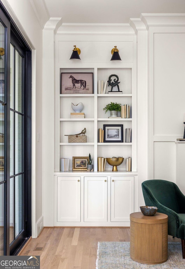 interior details with ornamental molding, wood-type flooring, and built in features