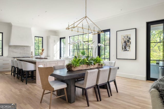 dining area featuring crown molding, a wealth of natural light, and light wood-type flooring