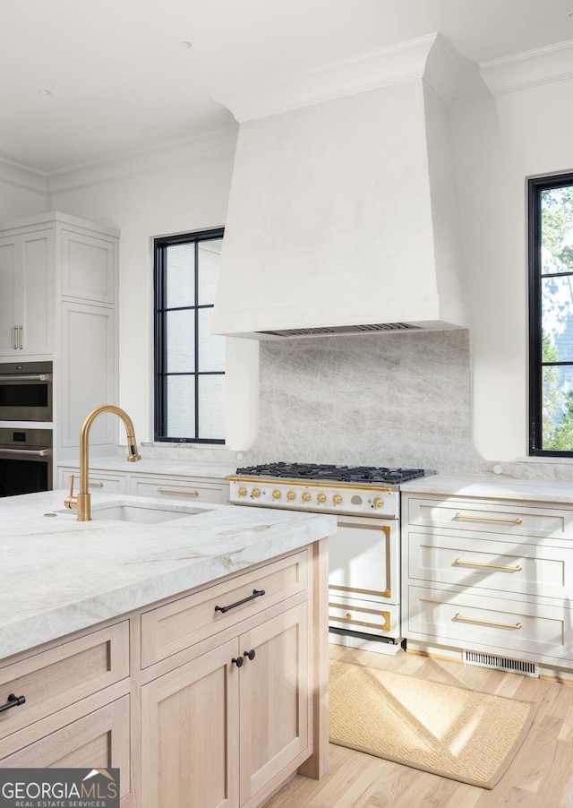 kitchen with sink, decorative backsplash, ornamental molding, white range oven, and light brown cabinets