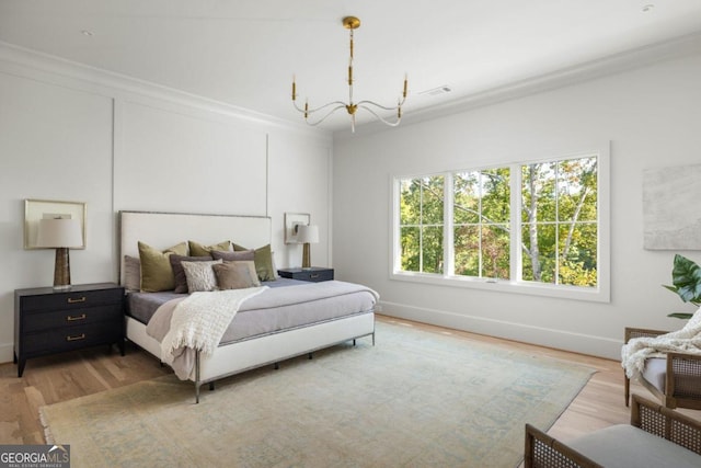 bedroom with ornamental molding, a chandelier, and light hardwood / wood-style flooring