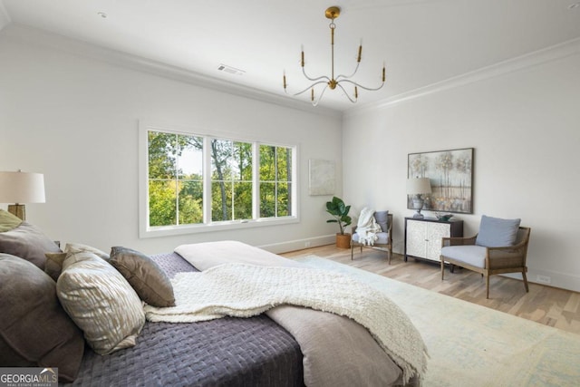 bedroom featuring crown molding, a chandelier, and light hardwood / wood-style flooring