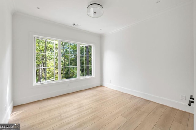 empty room with crown molding and light wood-type flooring