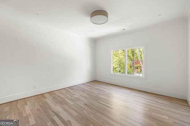 unfurnished room with ornamental molding and light wood-type flooring