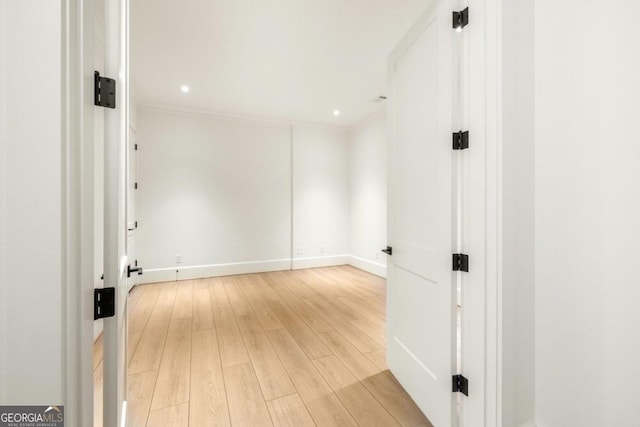 unfurnished room featuring crown molding and light hardwood / wood-style flooring