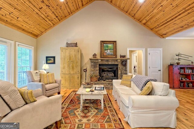 living room with wood ceiling, high vaulted ceiling, and light hardwood / wood-style floors