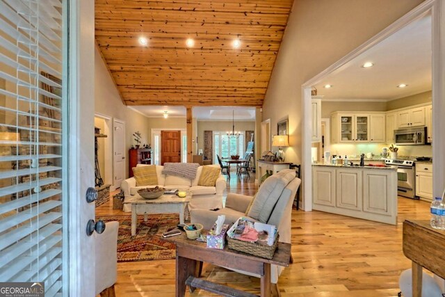 living room featuring high vaulted ceiling, light hardwood / wood-style flooring, a notable chandelier, and wooden ceiling