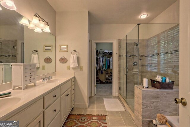 bathroom with a shower with door, tile patterned floors, and vanity