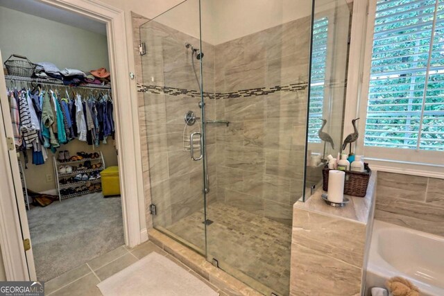 bathroom with separate shower and tub and tile patterned flooring