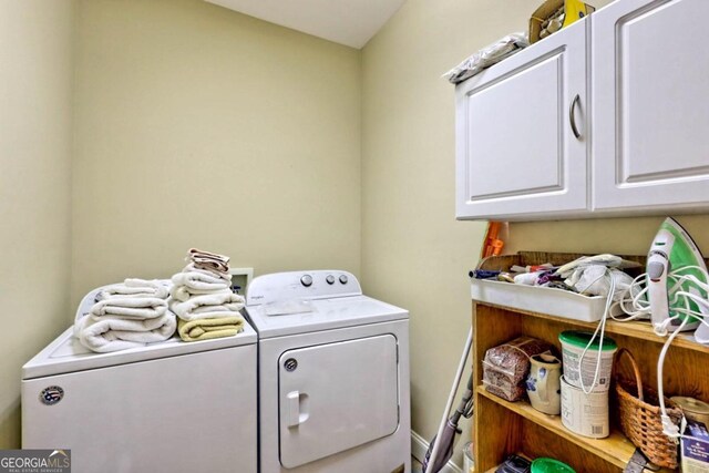 clothes washing area featuring cabinets and independent washer and dryer