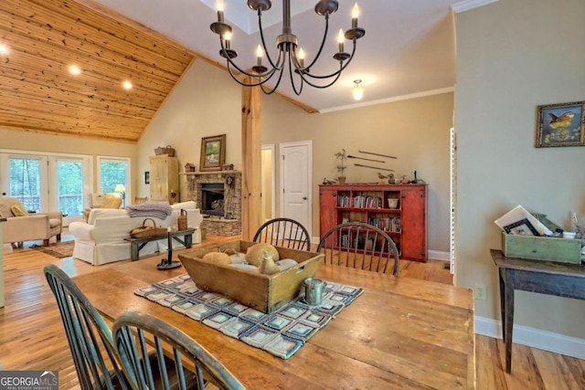 10 Quiet Place Ln, Clayton, GA 30525 - dining room with a chandelier, a fireplace with raised hearth, wood finished floors, baseboards, and high vaulted ceiling