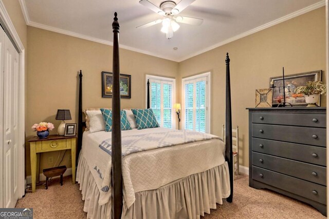 carpeted bedroom featuring ornamental molding, a closet, and ceiling fan