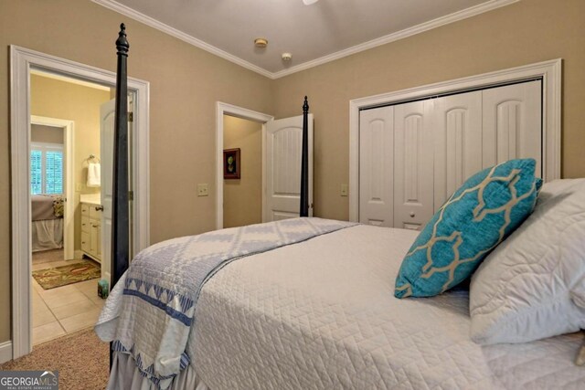 bedroom with light carpet, a closet, ensuite bath, and crown molding