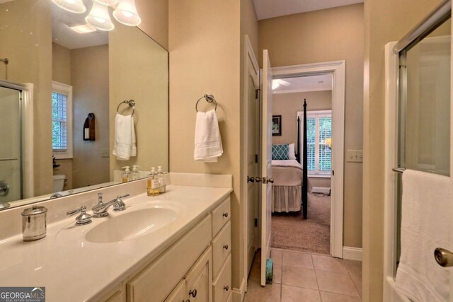 bathroom with toilet, an enclosed shower, a healthy amount of sunlight, and vanity