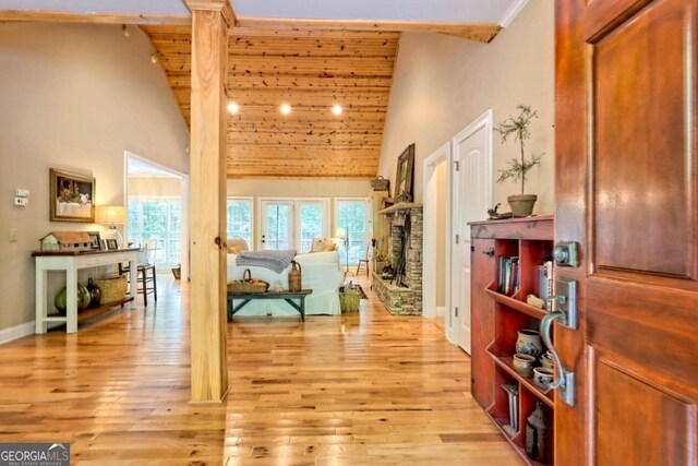 hallway featuring light hardwood / wood-style flooring and high vaulted ceiling