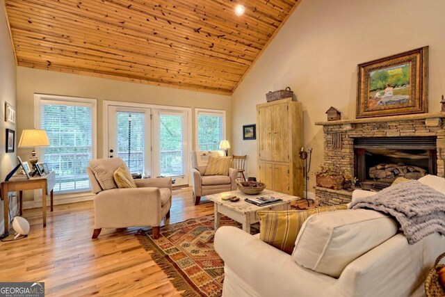 living room featuring light hardwood / wood-style floors, wood ceiling, high vaulted ceiling, and plenty of natural light