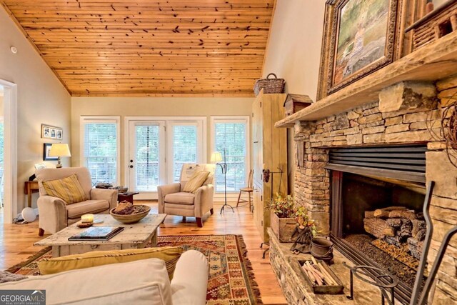 living room with a stone fireplace, wood ceiling, lofted ceiling, and light wood-type flooring