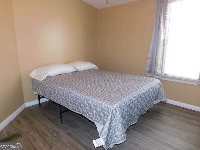 bedroom with dark wood-type flooring