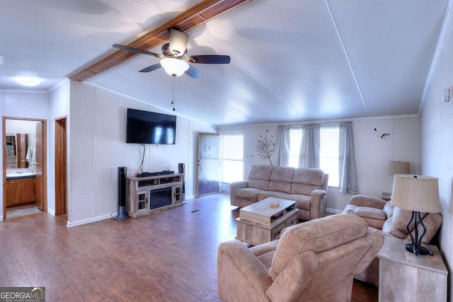 living room featuring wood-type flooring, vaulted ceiling, ornamental molding, ceiling fan, and a fireplace