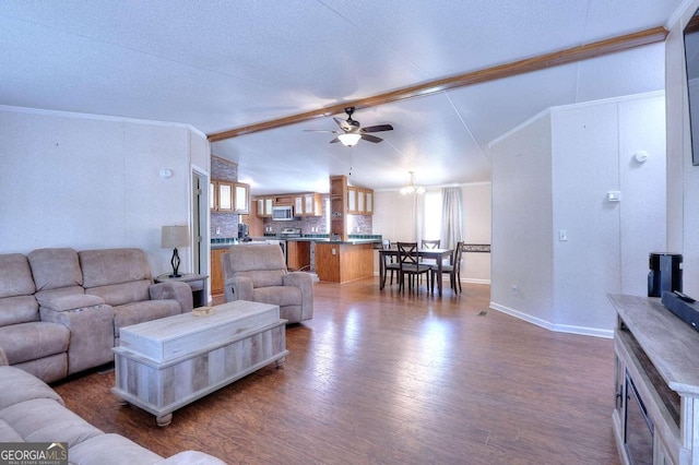 living room with wood-type flooring, vaulted ceiling with beams, ceiling fan with notable chandelier, and ornamental molding