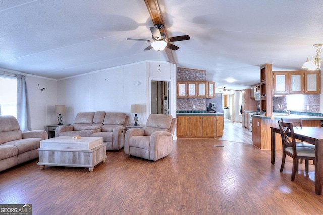 living room with lofted ceiling with beams, ceiling fan with notable chandelier, and hardwood / wood-style floors