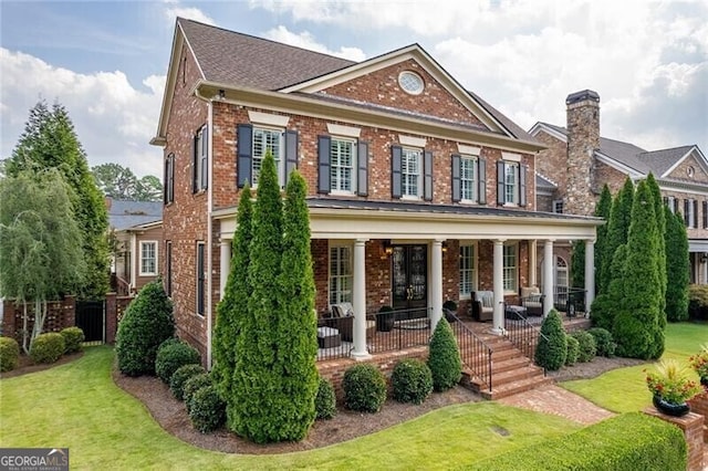 view of front of house with a porch and a front lawn