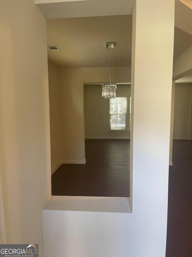 unfurnished dining area with a notable chandelier and hardwood / wood-style floors