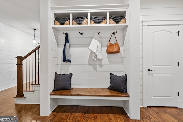 mudroom with wood-type flooring and wooden walls