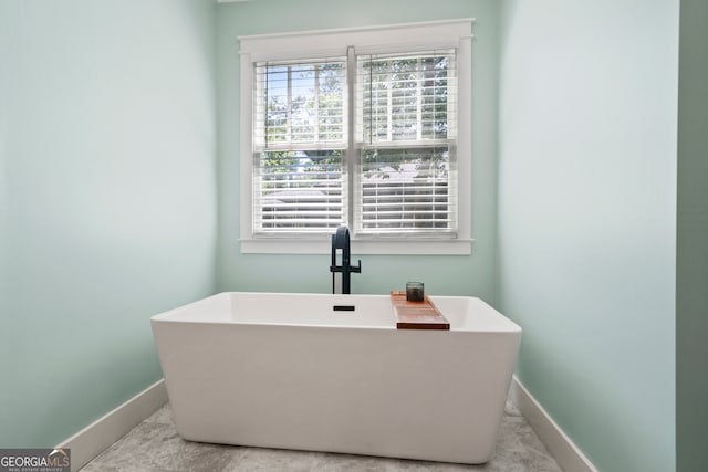 bathroom with a tub to relax in and sink