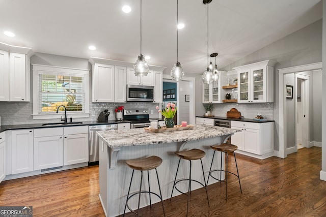 kitchen with pendant lighting, white cabinets, sink, and appliances with stainless steel finishes