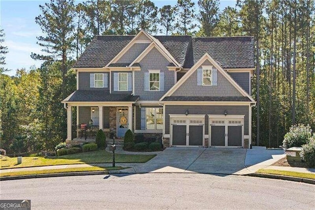 craftsman inspired home featuring a garage, a front lawn, and a porch