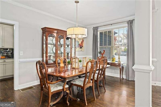 dining area featuring ornate columns, crown molding, and dark hardwood / wood-style floors