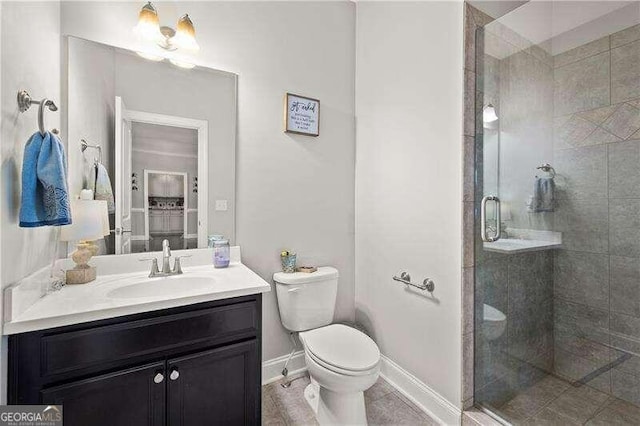 bathroom with vanity, toilet, tile patterned floors, and a shower with door