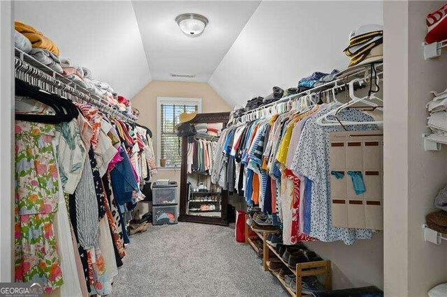 spacious closet with carpet flooring and vaulted ceiling