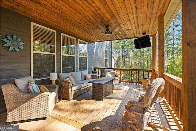 wooden terrace with ceiling fan and an outdoor living space