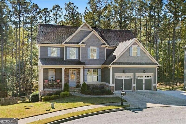 craftsman-style house with covered porch, a front yard, and a garage