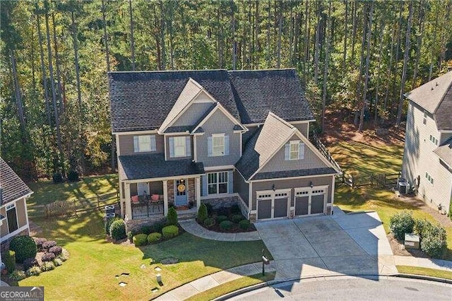 craftsman house with covered porch, a front lawn, and a garage