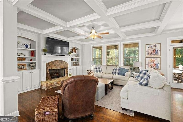 living room with a stone fireplace, dark hardwood / wood-style floors, ceiling fan, and built in shelves