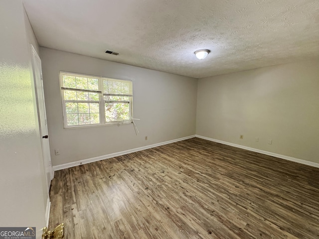 spare room with hardwood / wood-style floors and a textured ceiling