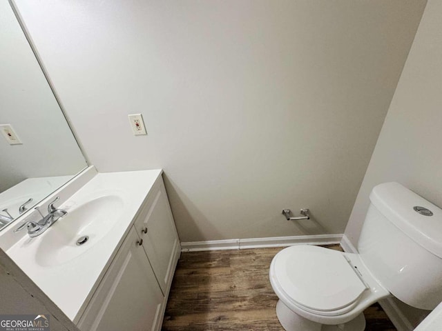 bathroom with hardwood / wood-style flooring, vanity, and toilet