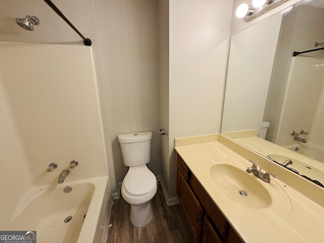 full bathroom with hardwood / wood-style flooring, vanity, toilet, and washtub / shower combination