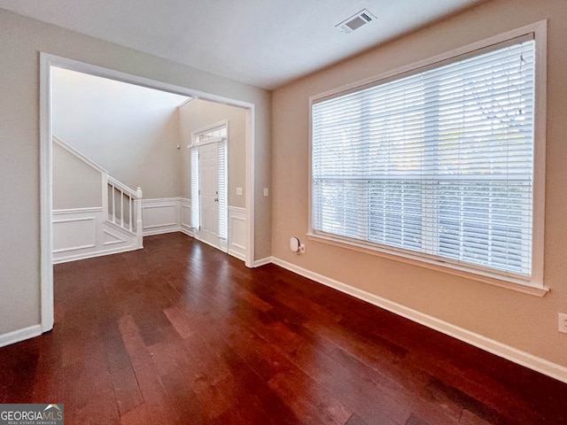 entrance foyer with dark wood-type flooring and a healthy amount of sunlight