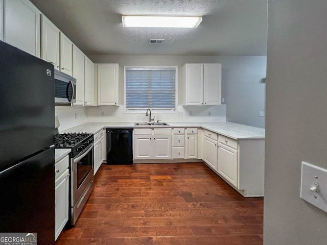 kitchen featuring dark hardwood / wood-style flooring, a textured ceiling, white cabinetry, black appliances, and sink