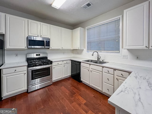 kitchen with appliances with stainless steel finishes, sink, dark hardwood / wood-style flooring, white cabinets, and light stone counters