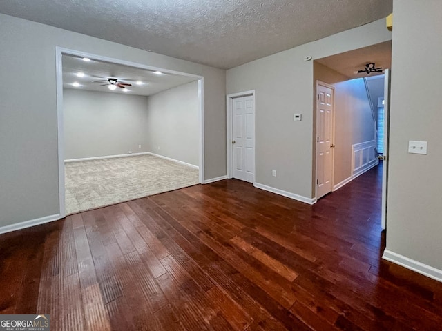 unfurnished room with dark wood-type flooring, ceiling fan, and a textured ceiling