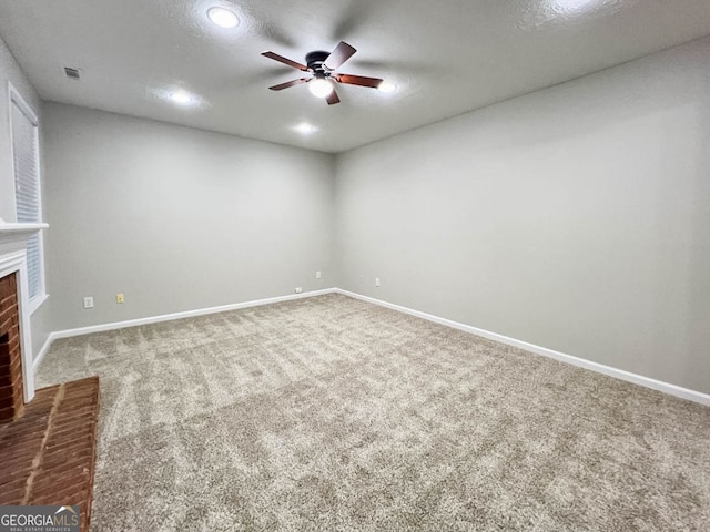 interior space with a textured ceiling, ceiling fan, a fireplace, and carpet flooring