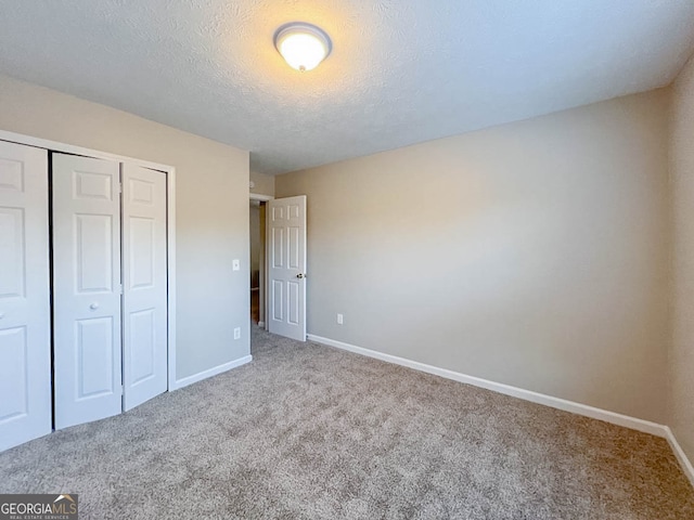 unfurnished bedroom featuring a closet, carpet, and a textured ceiling