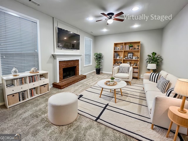 living room with light colored carpet, a fireplace, and ceiling fan